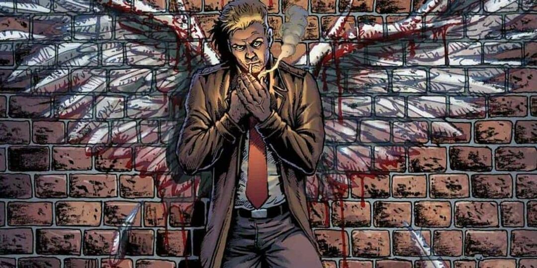 Constantine encostado em uma parede com asas de anjo pintadas na DC Comics.