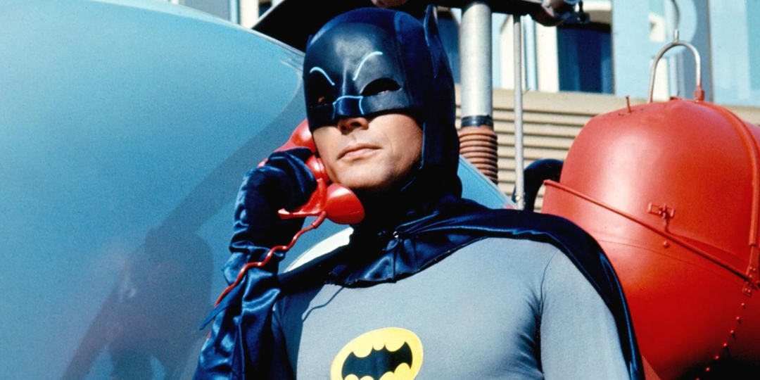 Adamas Westas kaip Betmenas, atsiliepiantis raudonu šikšnosparnio telefonu 166 Betmeno serijoje