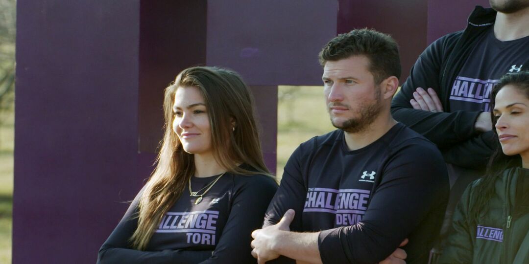 Tori Deal și Devin Walker în The Challenge: Ride or Dies stau în picioare unul lângă altul cu brațele încrucișate