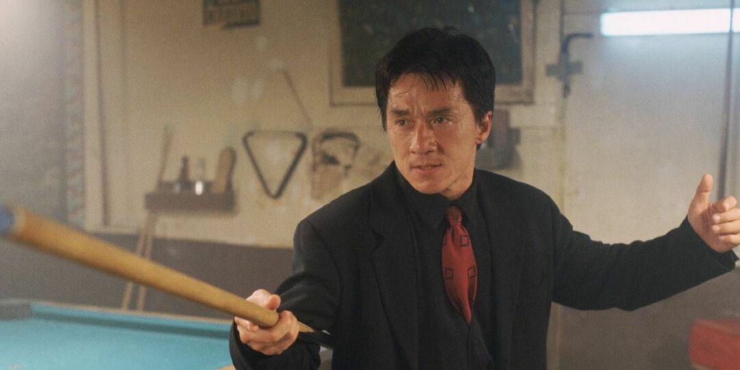 Jackie Chan drži palico za biljard v prometni konici.